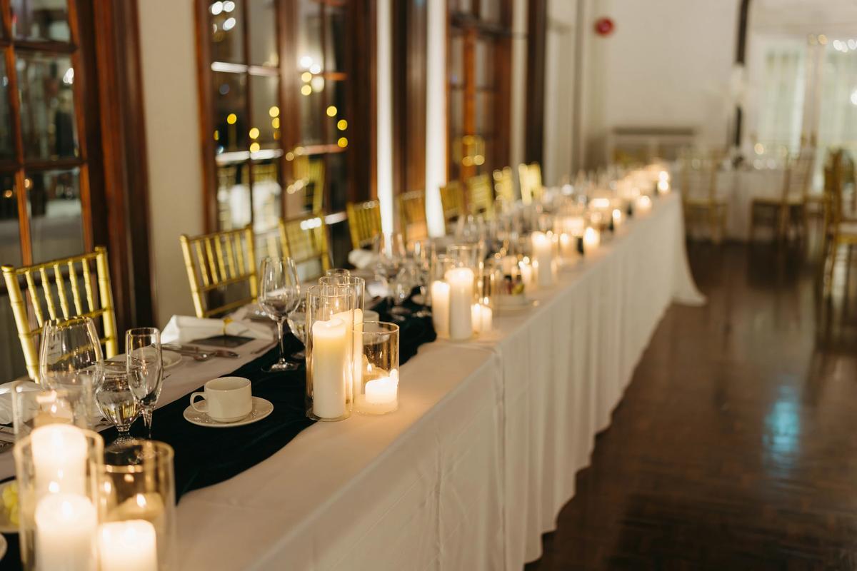 Elegant candlelit reception setup at the Boulevard Club in Toronto with gold accents and floral centerpieces